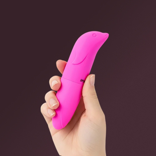 Golfinho vibrador rosa segurado na mão, oferecido como brinde grátis